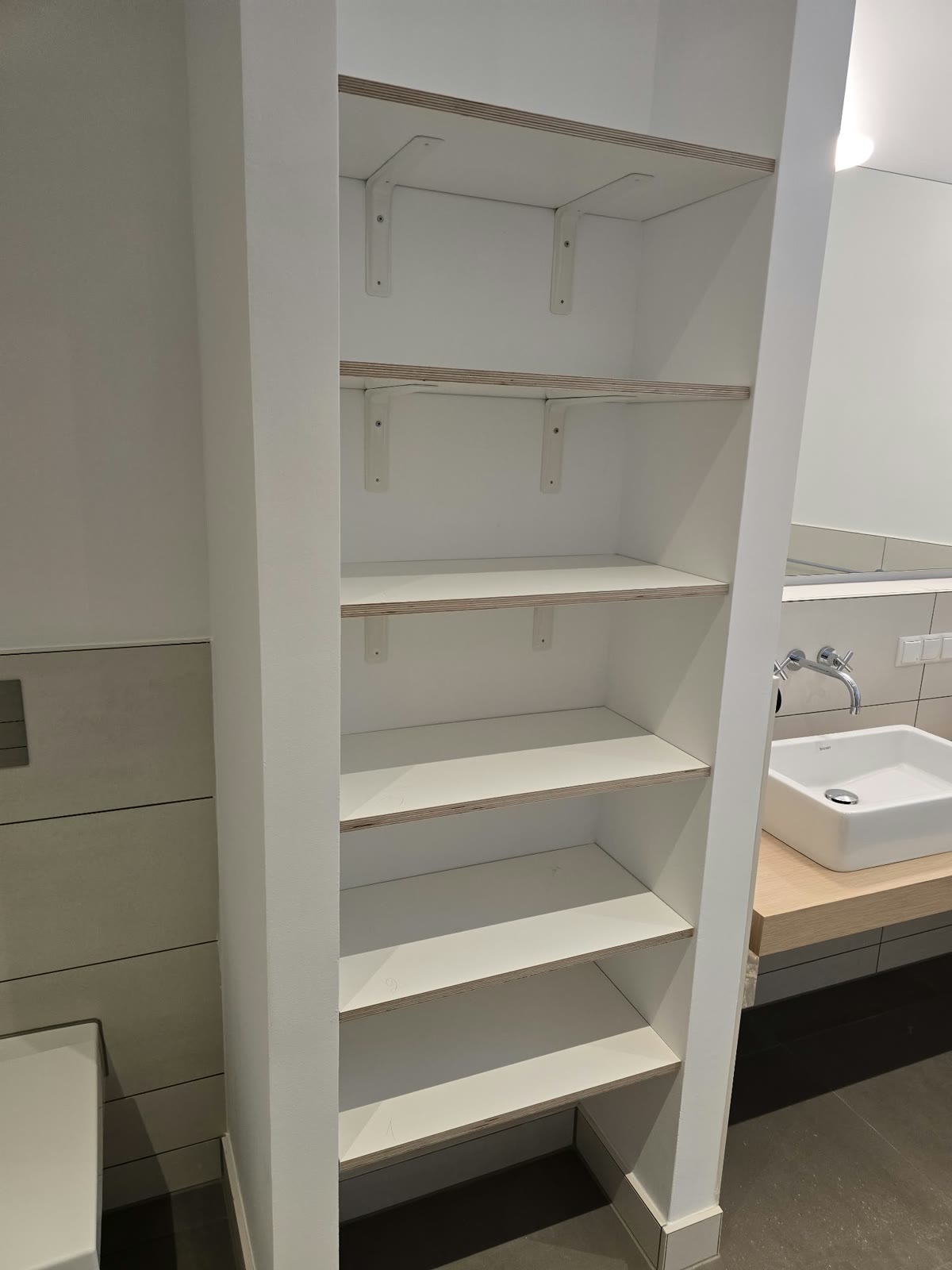 Offenes, noch unfertiges Einbauregal im Badezimmer vor dem Einbau der Schrankfronten